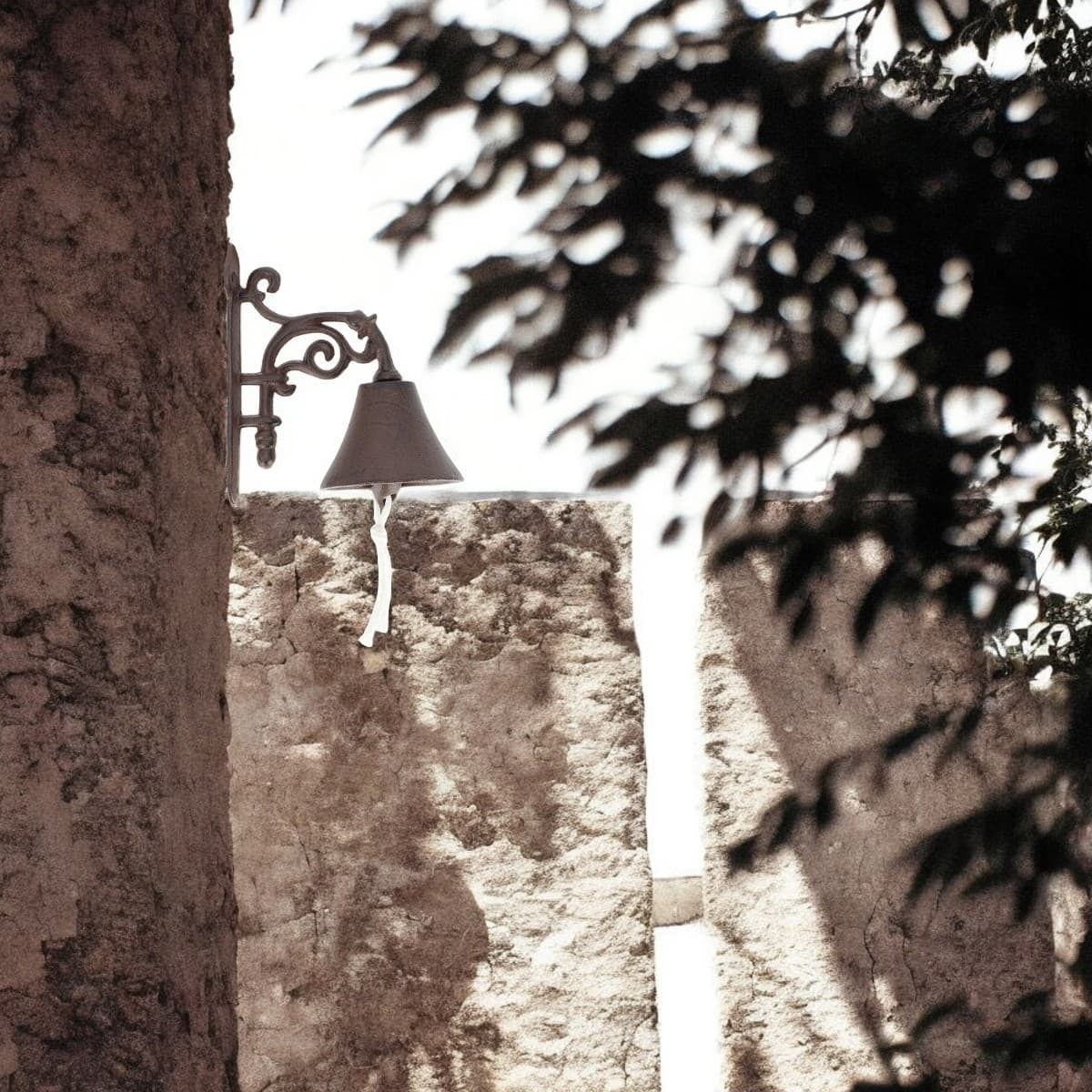 cloche fleur accrochée sur un mur en pierre