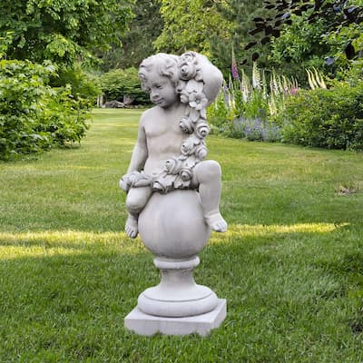 Statue ange sur colonne boule entouré de fleurs